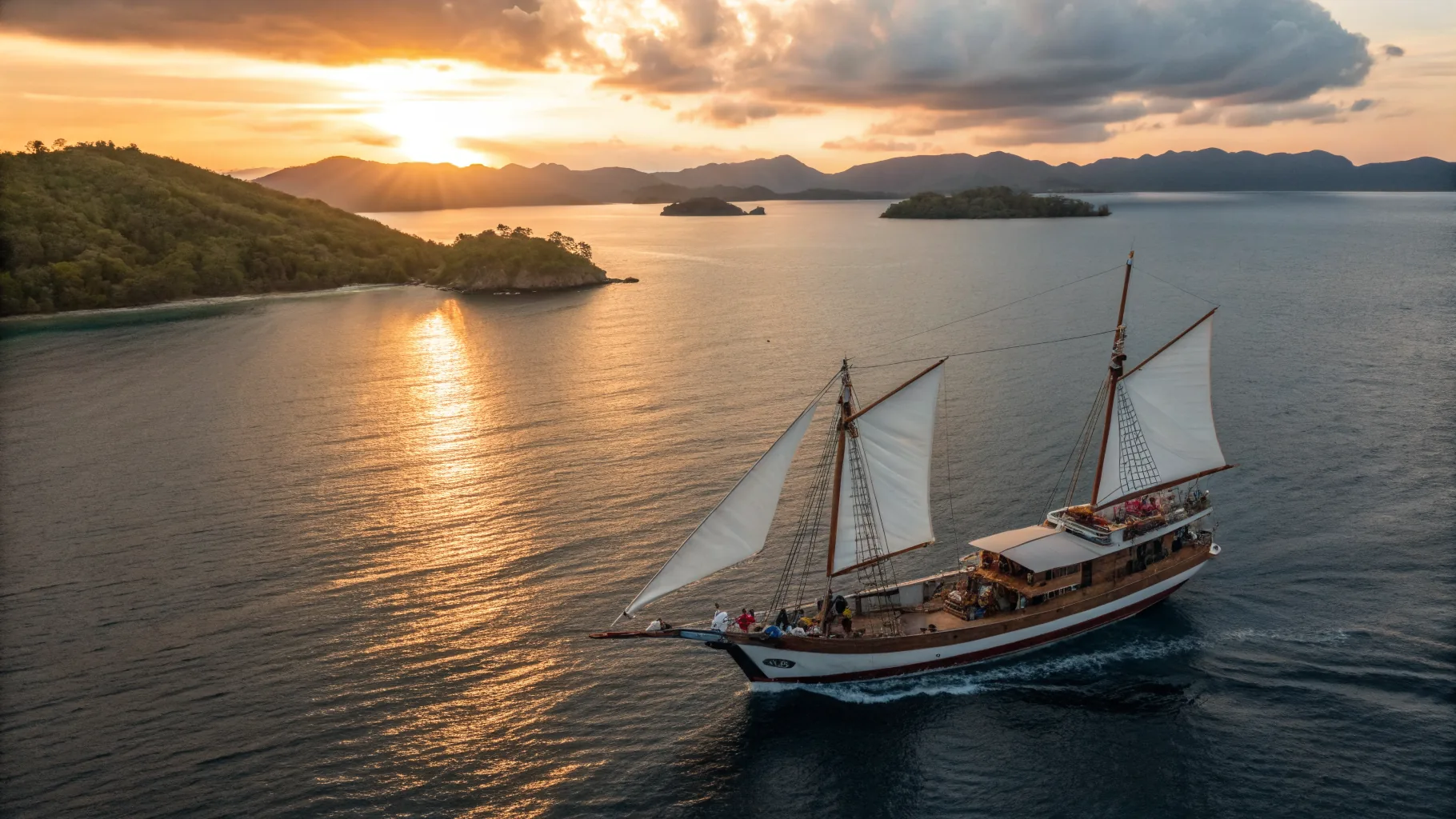 Traditional Indonesian phinisi yacht with full sails departing Benoa Harbor Bali at golden hour